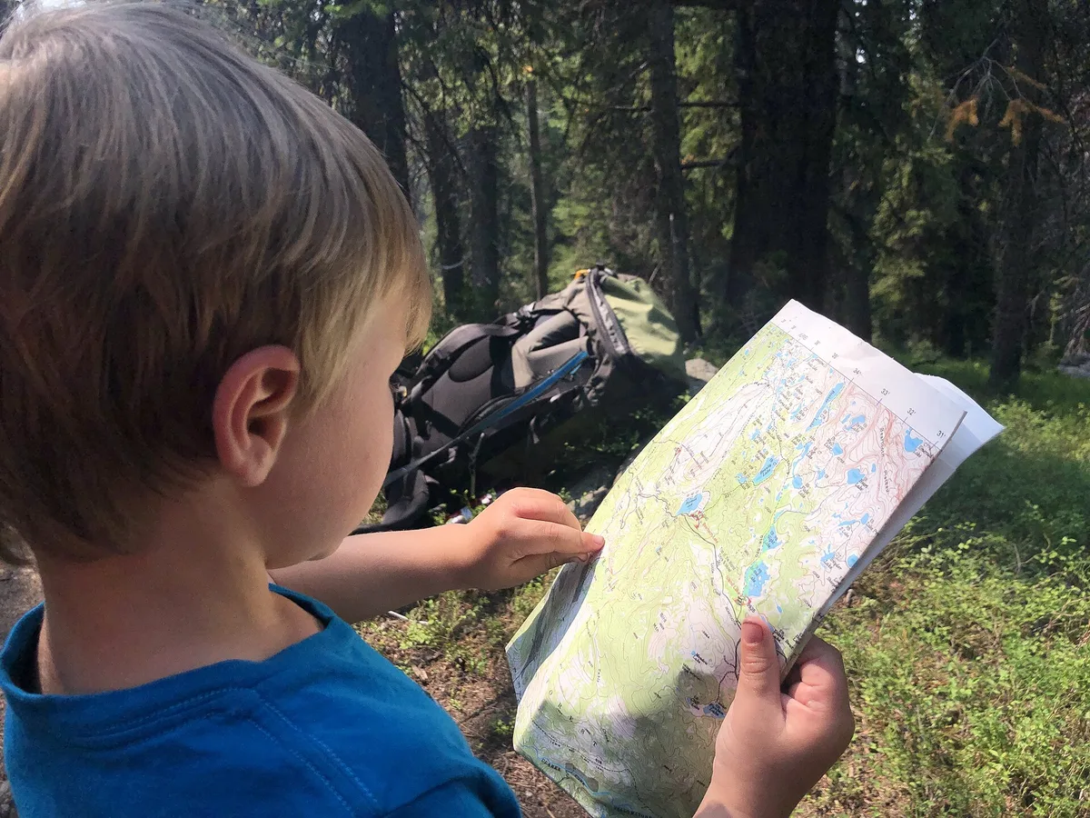 A walker checking a topographic map before setting off, the sort of map that goes hand in hand with the best hiking books