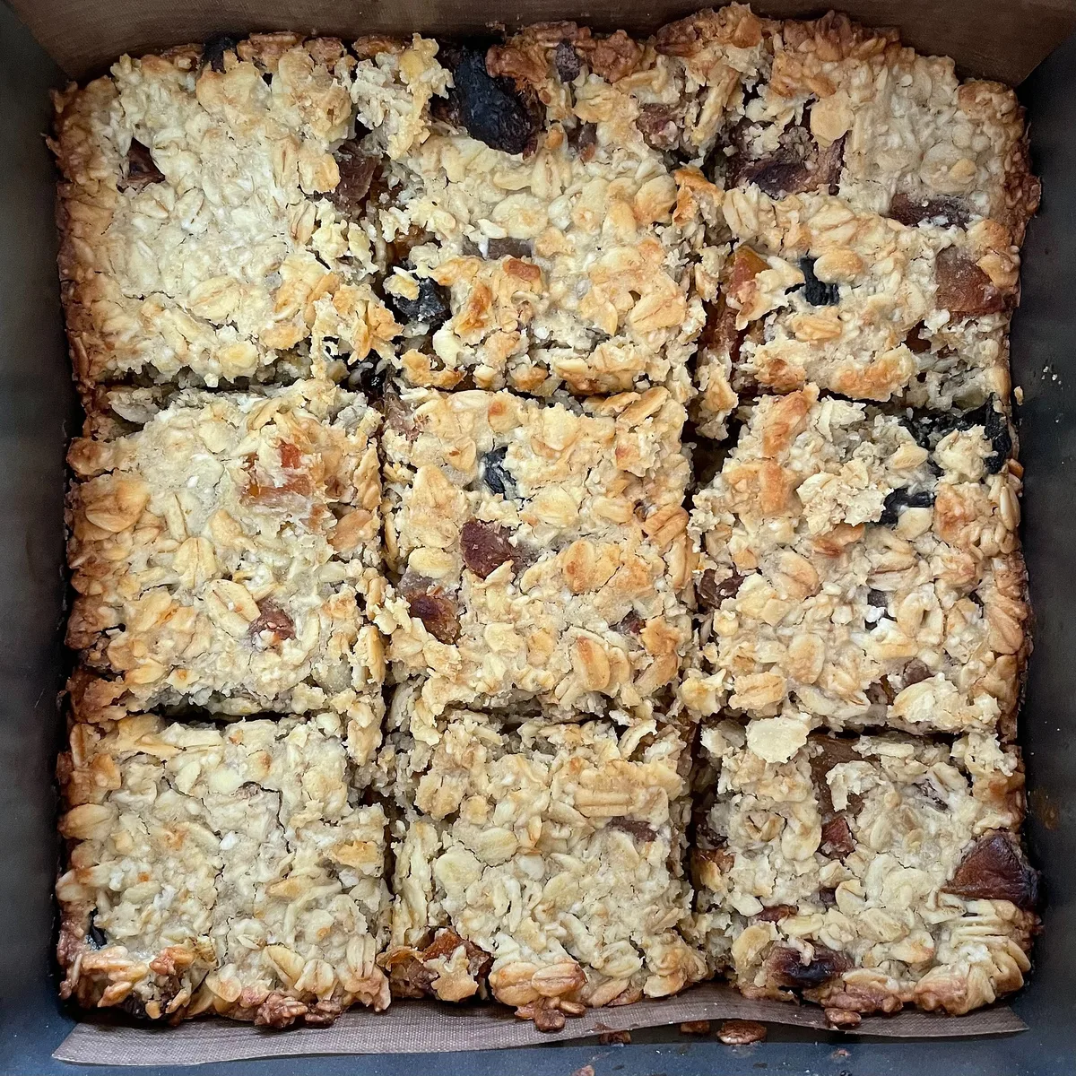 Tray of homemade oat flapjacks with dried fruit, an easy energy bar to pack as a hiking snack for Ireland's trails